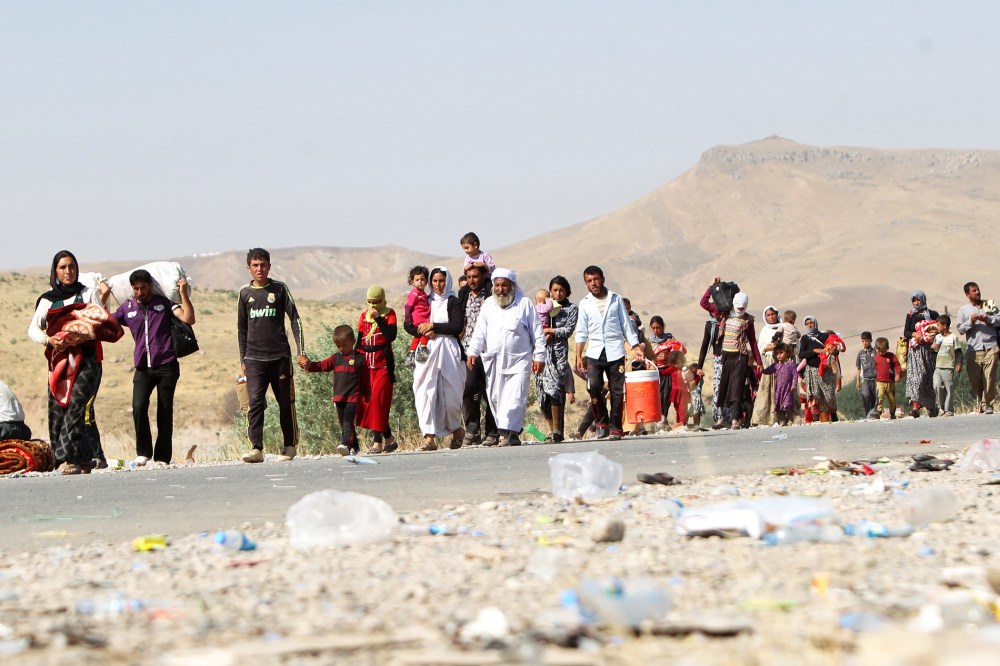 Displaced Iraqi families from the Yazidi community cross the Iraqi-Syrian border at the Fishkhabur crossing, in northern Iraq, on August 13, 2014.