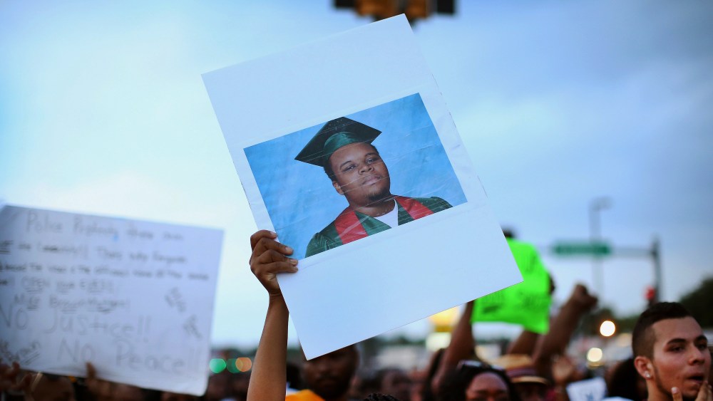 A demonstrator carries a picture of Michael Brown during a protest along Florissant Avenue on Aug. 16, 2014 in Ferguson, Mo.