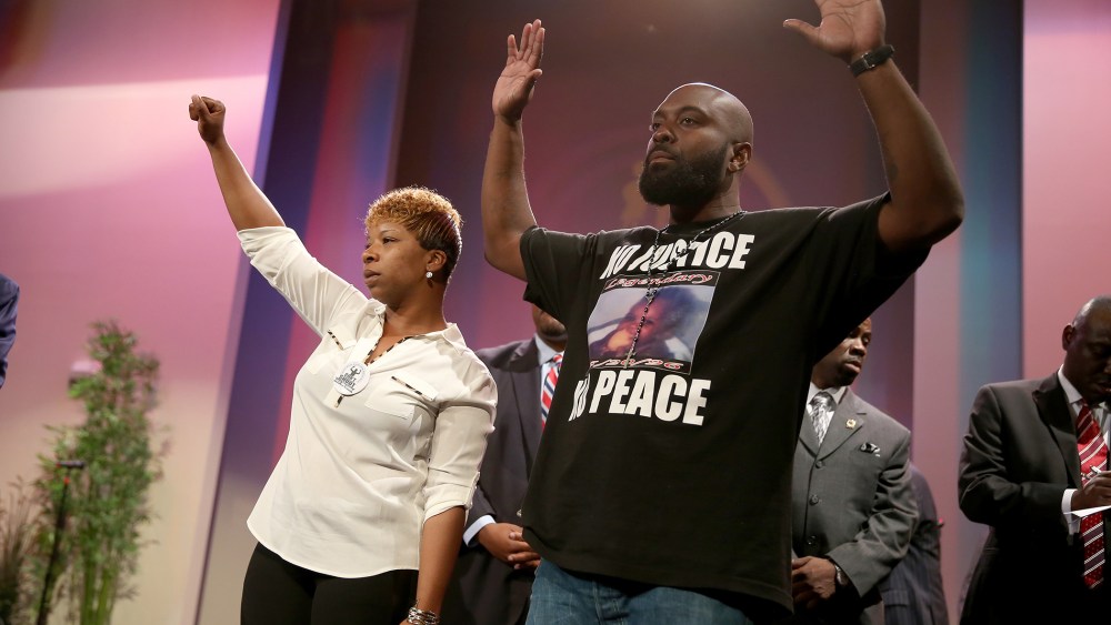 Lesley McSpadden (L) and Michael Brown, the parents of slain 18-year-old Michael Brown, acknowledge a crowd during an event at the Greater Grace Church on Aug. 17, 2014 in Ferguson, Mo. (Photo by Joe Raedle/Getty)