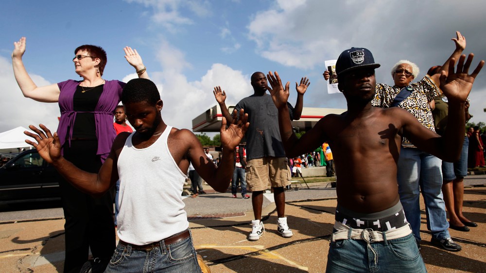Demonstrators protest Michael Brown's murder with their hands in the air August 17, 2014 in Ferguson, Missouri.