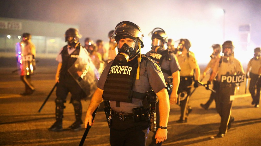 Police advance through a cloud of tear gas toward demonstrators protesting the killing of teenager Michael Brown on Aug. 17, 2014 in Ferguson, Mo.