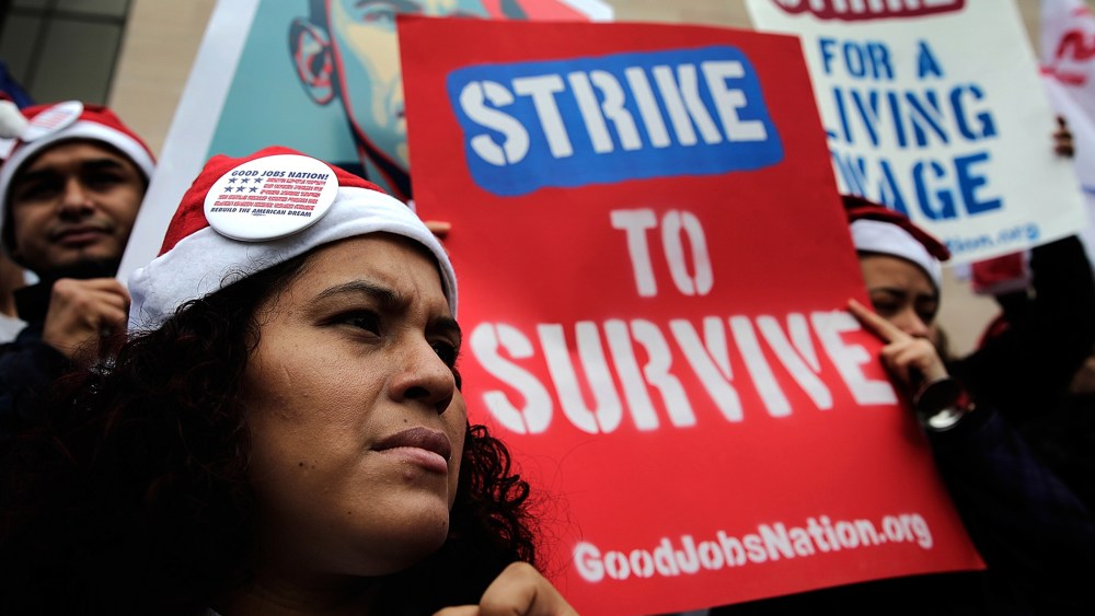 Low wage workers join with supporters of an increase in the minimum wage during a protest outside the Air and Space Museum, Dec. 5, 2013 in Washington, D.C.