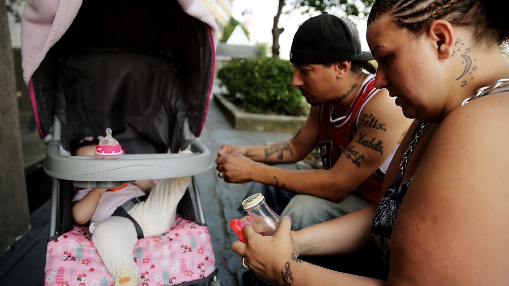 Michell and Alex, who are homeless, sit outside of the Pan Am Shelter in Queens with their daughter Alexis on Aug. 20, 2014 in New York City. (Photo by Spencer Platt/Getty)