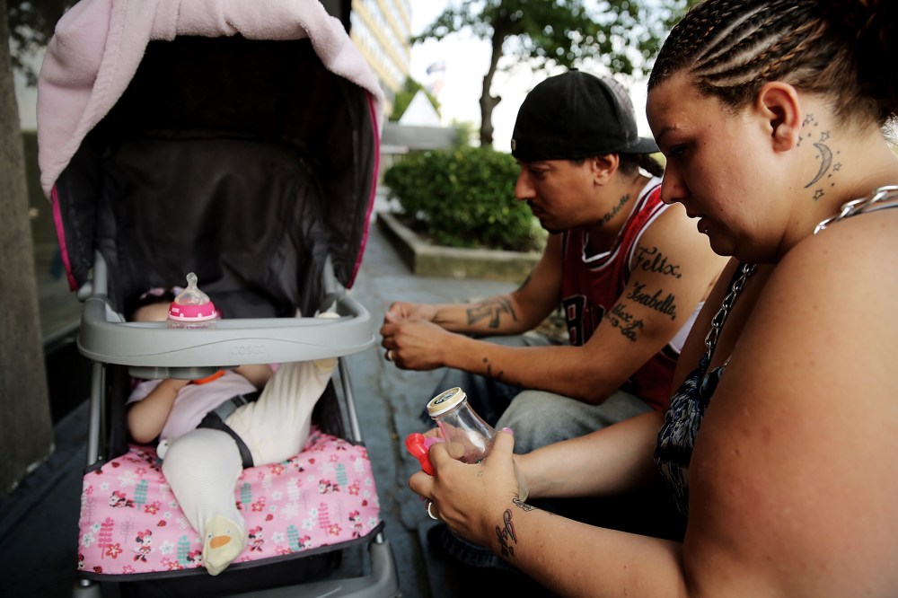 Michell and Alex, who are homeless, sit outside of the Pan Am Shelter in Queens with their daughter Alexis on Aug. 20, 2014 in New York City. (Photo by Spencer Platt/Getty)