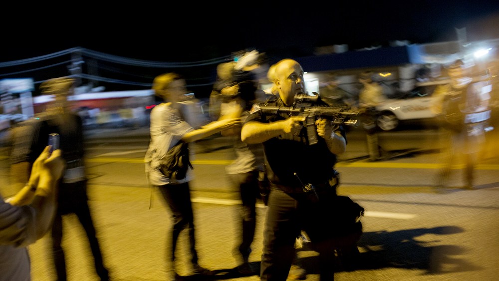 St. Ann, Missouri police officer Lt. Ray Albers points an assault rifle during a protest of the death of teenager Michael Brown on Aug. 19, 2014 in Ferguson, Mo.