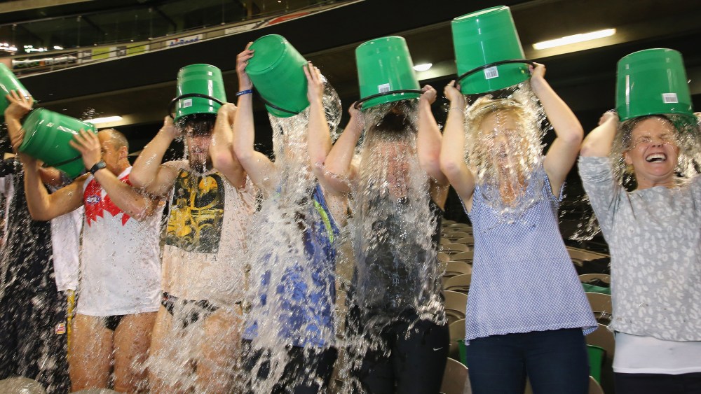 Participants tip buckets of ice water over their heads as they take part in the World Record Ice Bucket Challenge at Etihad Stadium on August 22, 2014 in Melbourne, Australia.