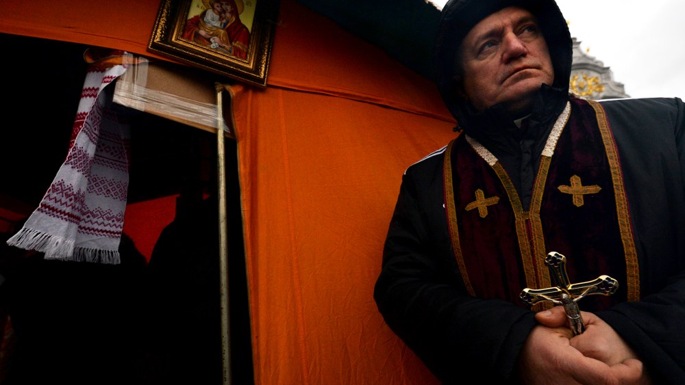 A priest of the Greek Catholic Church holds a crucifix on Independence Square in Kiev, Dec. 7, 2013.