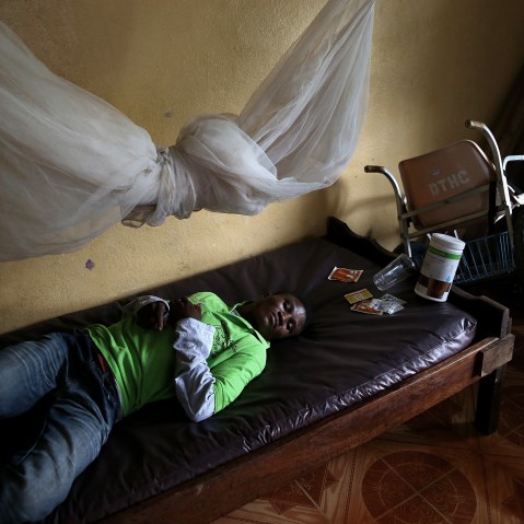 John Karpee, 24, lies in an observation room at a government clinic on Aug. 24, 2014 in Dolo Town, Liberia.