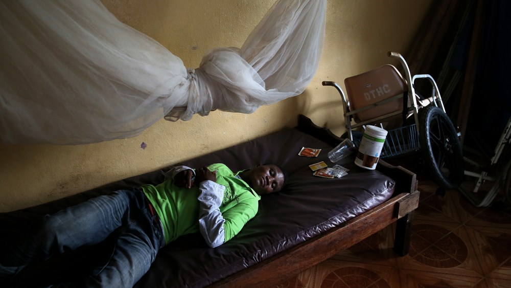 John Karpee, 24, lies in an observation room at a government clinic on Aug. 24, 2014 in Dolo Town, Liberia.