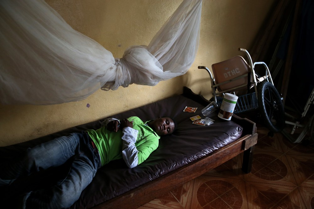 John Karpee, 24, lies in an observation room at a government clinic on Aug. 24, 2014 in Dolo Town, Liberia.