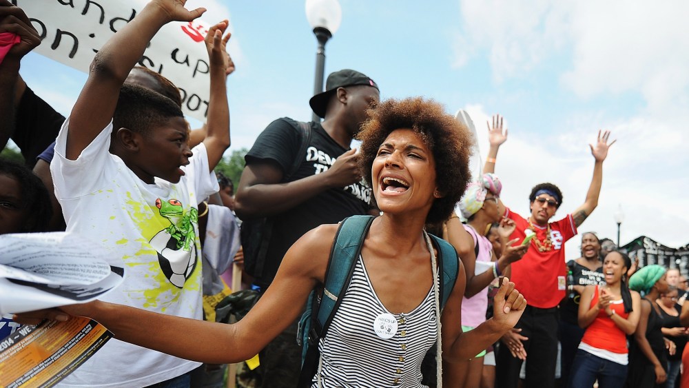 Demonstrators protest outside the Ferguson, Missouri, police department during the National March on Ferguson, August 30, 2014.