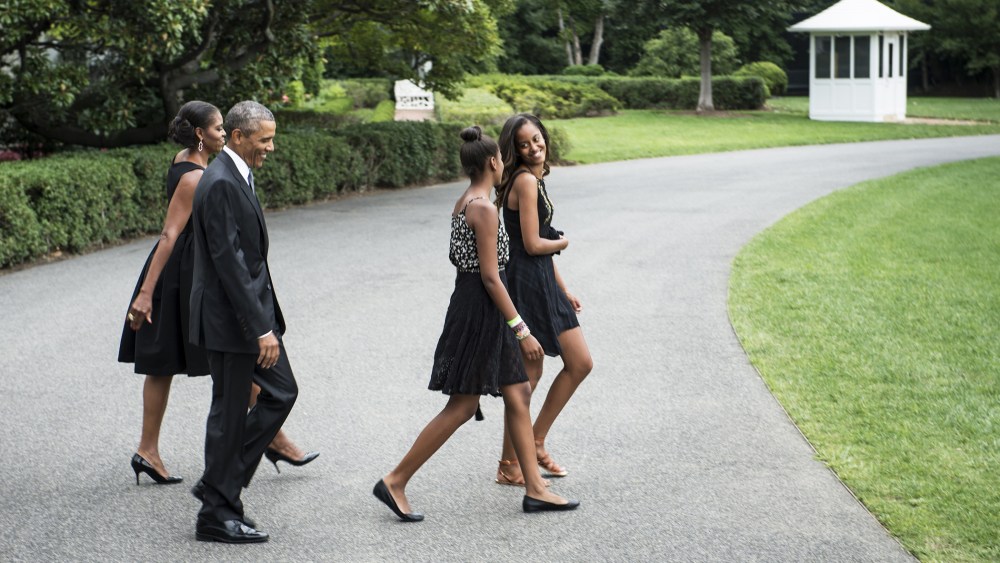 US President Barack Obama (2L) and US First Lady Michelle Obama (L) catch up to their daughters Sasha (2R) and Malia while walking to Marine One on the South Lawn of the White House on Aug. 30, 2014 in Washington, DC.