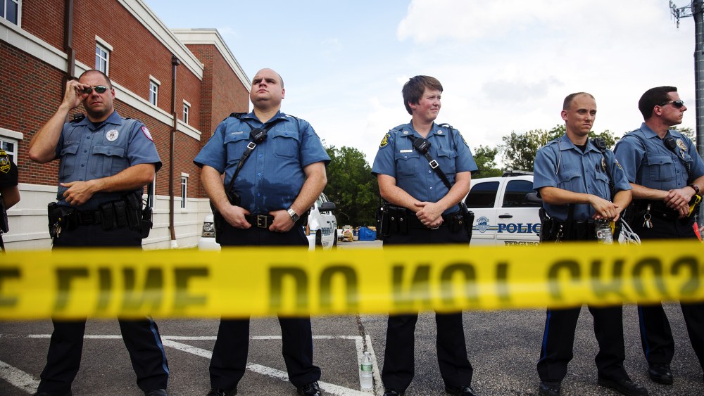 Police stand guard during a rally for Michael Brown outside the Ferguson Police Department August 30, 2014 in Ferguson, Missouri.