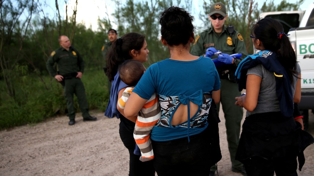 Families of Central American immigrants turn themselves in to US Border Patrol agents after crossing the Rio Grande River from Mexico on Sep. 8, 2014 to McAllen, Texas. (Photo by John Moore/Getty)