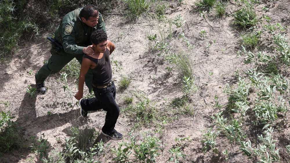 A U.S. Border Patrol agent detains an undocumented immigrant who fled from agents through dense brush on Sept. 9, 2014 near Falfurrias, Texas.
