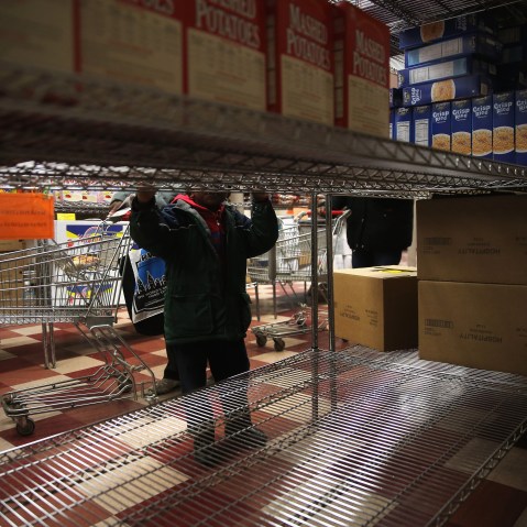 A child accompanies his grandmother choosing free groceries at a food pantry run by the Food Bank For New York City on Dec. 11, 2013 in New York City. (John Moore/Getty)