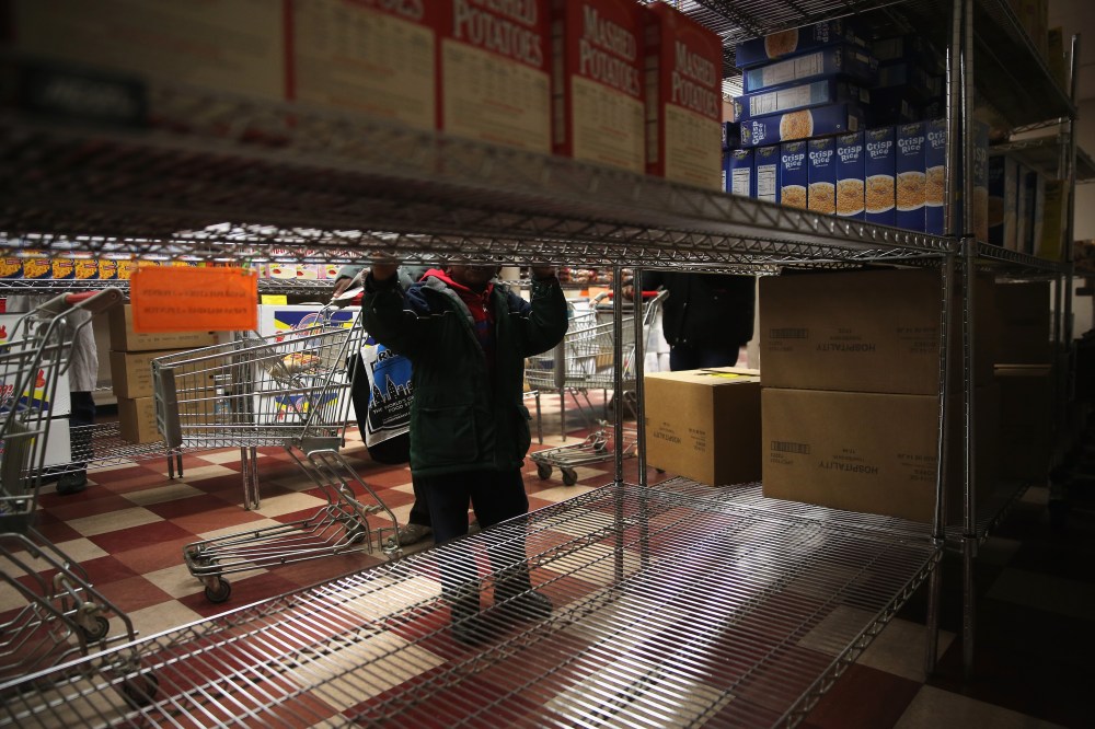A child accompanies his grandmother choosing free groceries at a food pantry run by the Food Bank For New York City on Dec. 11, 2013 in New York City. (John Moore/Getty)