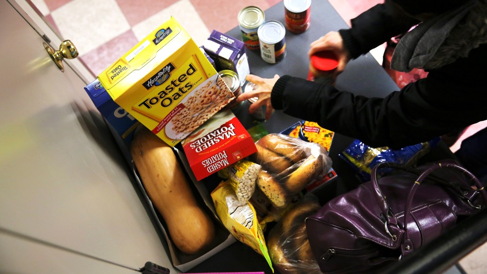 People receive free groceries at a food pantry run by the Food Bank For New York City, Dec. 11, 2013. (Photo by John Moore/Getty)