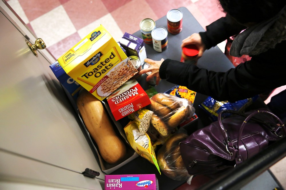 People receive free groceries at a food pantry run by the Food Bank For New York City, Dec. 11, 2013. (Photo by John Moore/Getty)