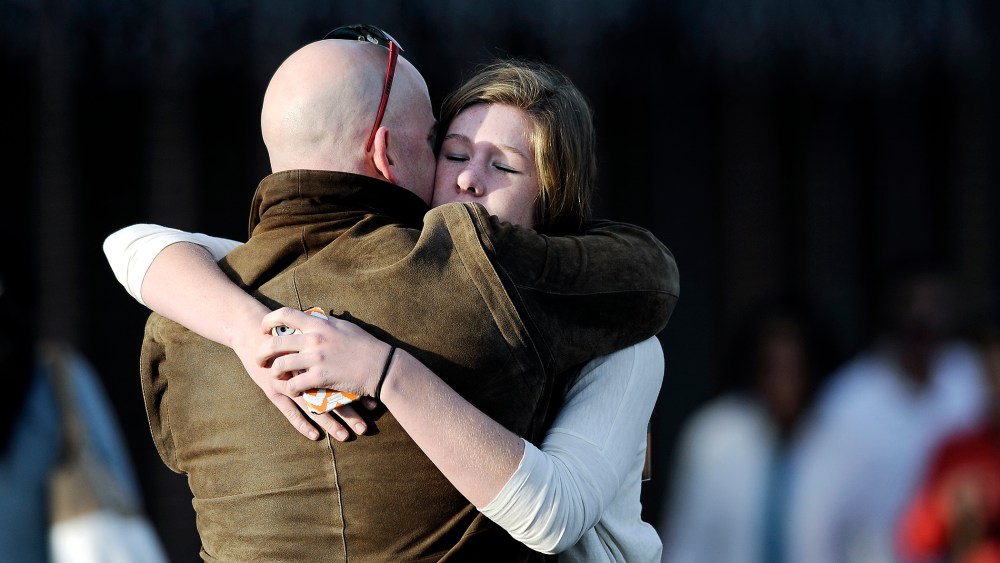 A man comforts a student outside Shepherd of the Hills Church after a school shooting at Arapahoe High School on Dec. 13, 2013 in Centennial, Colo.