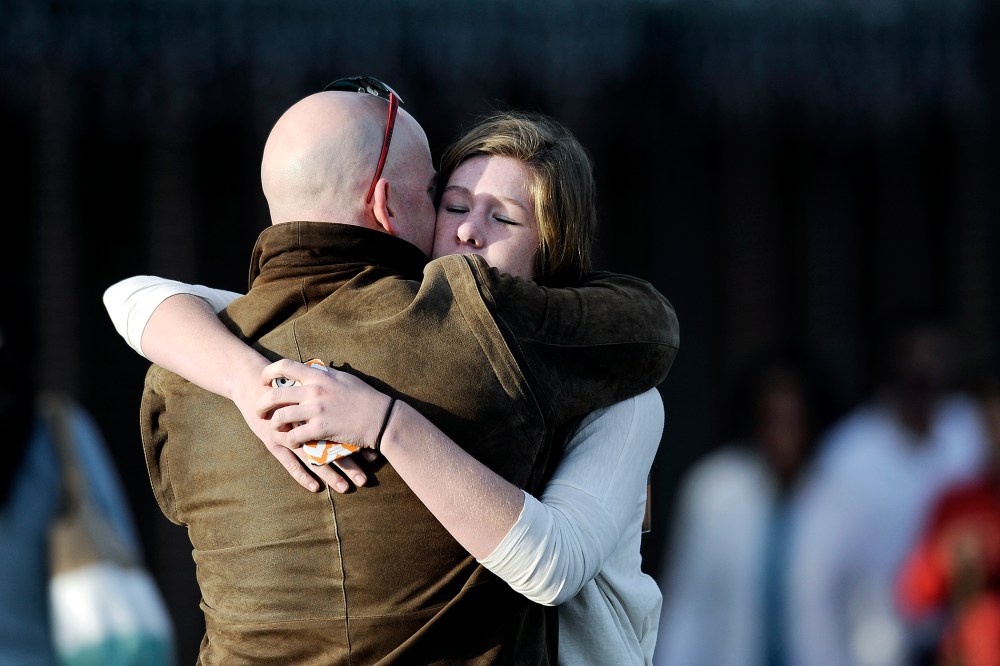 A man comforts a student outside Shepherd of the Hills Church after a school shooting at Arapahoe High School on Dec. 13, 2013 in Centennial, Colo.