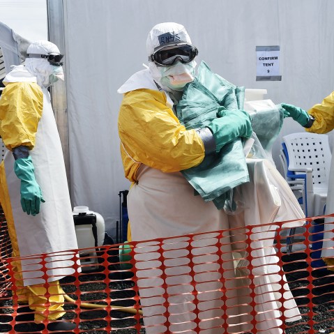 A health worker in protective suit carries equipment on October 1, 2014 at MSF's (Doctors Without Borders) Ebola treatment center in Monrovia.