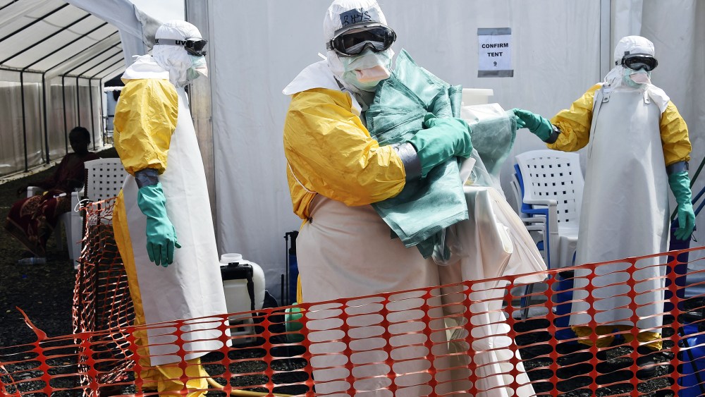 A health worker in protective suit carries equipment on October 1, 2014 at MSF's (Doctors Without Borders) Ebola treatment center in Monrovia.
