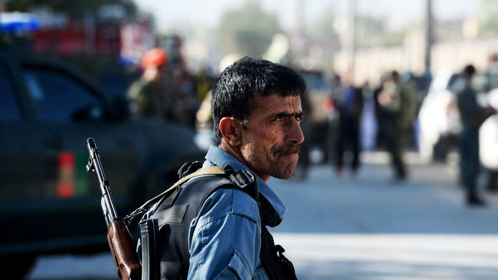 An Afghan policeman keeps watch at the site of a suicide attack in Kabul on October 2, 2014.