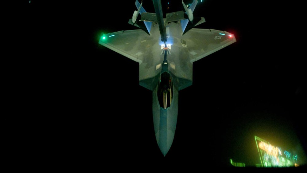 In this handout image provided by the U.S. Air Force, A KC-10 Extender refuels an F-22 Raptor fighter aircraft prior to strike operations in Syria, during flight on Sept. 26, 2014. (Photo by Tech. Sgt. Russ Scalf/U.S. Air Force /Getty)