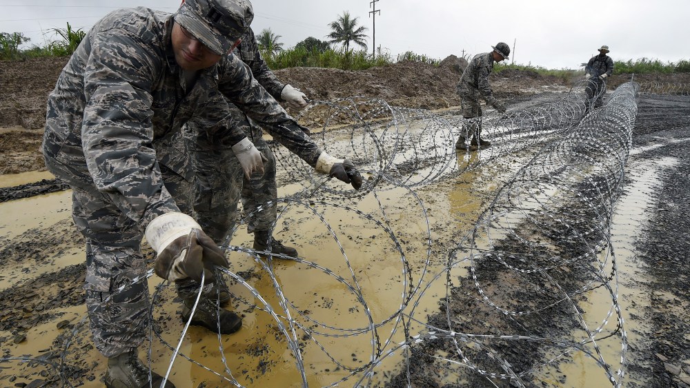 US Air Force soldiers place barbed wire in an area designated for a Ebola treatment center in Monrovia, on Oct. 6, 2014