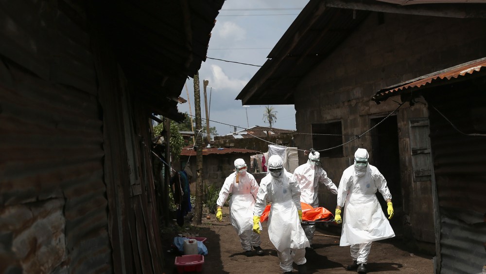 Ebola burial team members remove the body of Mekie Nagbe, 28, for cremation on Oct. 10, 2014 in Monrovia, Liberia.