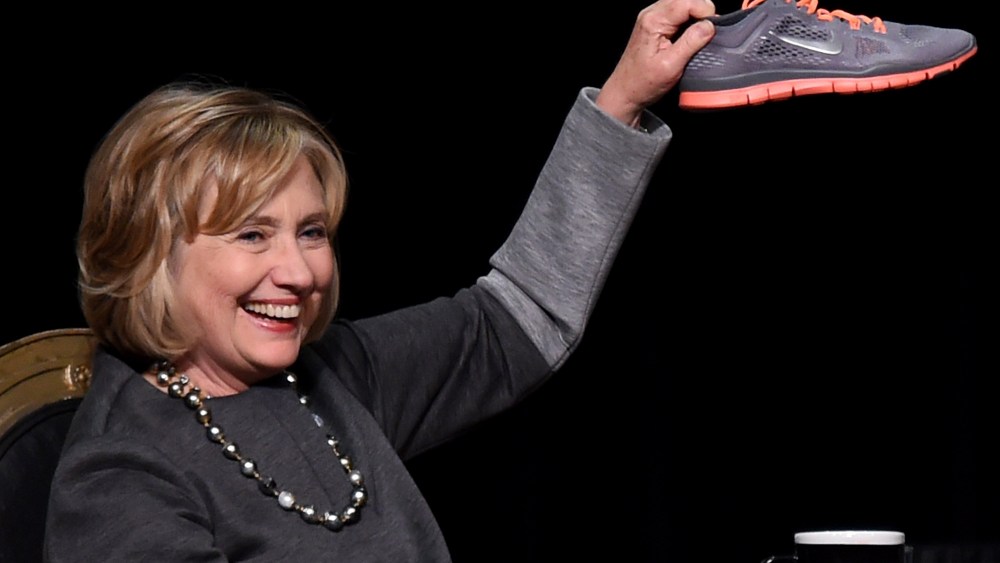 Former U.S. Secretary of State Hillary Clinton holds up a running shoe she received as a gift at a fundraising dinner for the UNLV Foundation at the Bellagio on Oct. 13, 2014 in Las Vegas.