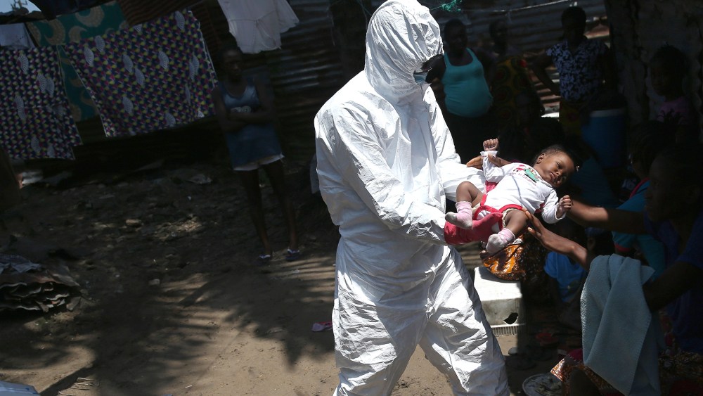 A health worker takes Benson, 2 months, from his mother to carry him to a re-opened Ebola holding center in the West Point neighborhood on Oct. 17, 2014 in Monrovia, Liberia. (John Moore/Getty)