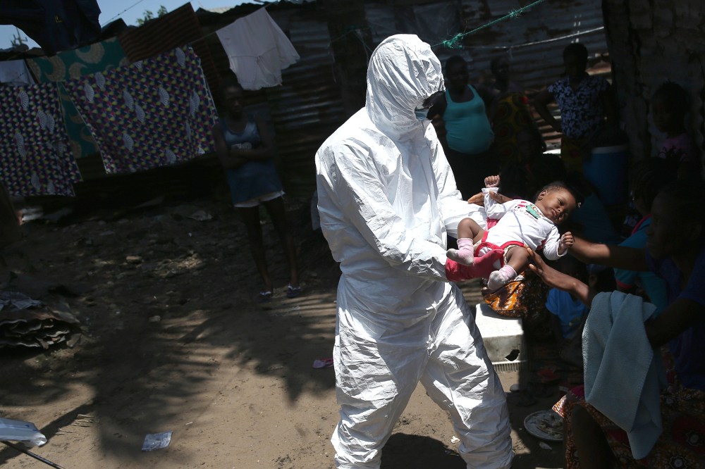A health worker takes Benson, 2 months, from his mother to carry him to a re-opened Ebola holding center in the West Point neighborhood on Oct. 17, 2014 in Monrovia, Liberia. (John Moore/Getty)