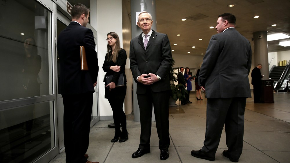 U.S. Senate Majority Leader Sen. Harry Reid (D-NV) (C) waits for the Senate subway after a vote December 17, 2013 on Capitol Hill in Washington, DC.
