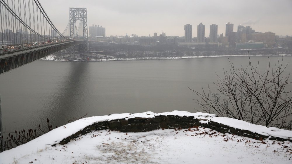 Snow covers the Palisades Interstate Park overlooking the George Washington Bridge between New York City (R), and Fort Lee, New Jersey on December 17, 2013.