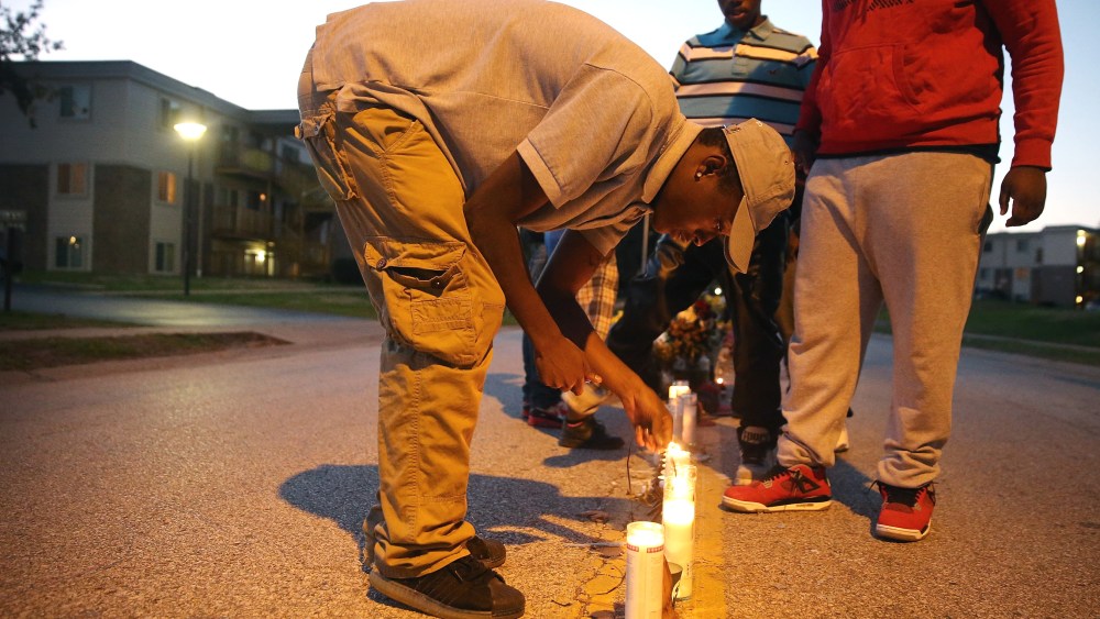Neighborhood residents light candles at a memorial for 18-year-old Michael Brown on Canfield Street on Oct. 20, 2014 in Ferguson, Mo.