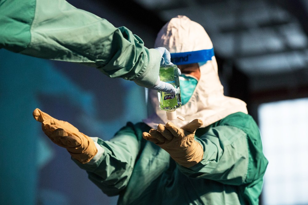 A nurse and a doctor demonstrate to health care professionals how to properly put on protective medical gear when working with someone infected with the ebola virus on Oct. 21, 2014 in New York, N.Y. (Photo by Andrew Burton/Getty)