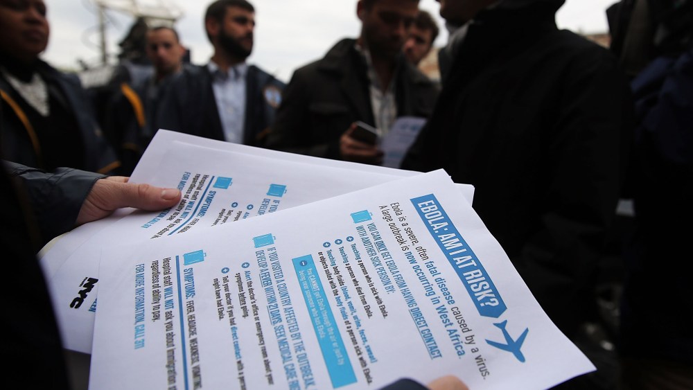 City workers hand out Ebola information sheets near The Gutter bowling alley where New York City's first Ebola patient visited before showing symptoms of the virus on Oct. 24, 2014 in New York City.