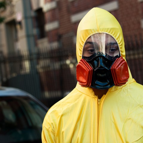 A young man, dressed in a biohazard costume, stands on the corner of 546 West 147th Street on October 25, 2014 in New York City.