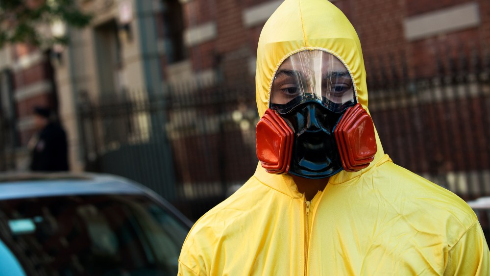A young man, dressed in a biohazard costume, stands on the corner of 546 West 147th Street on October 25, 2014 in New York City.
