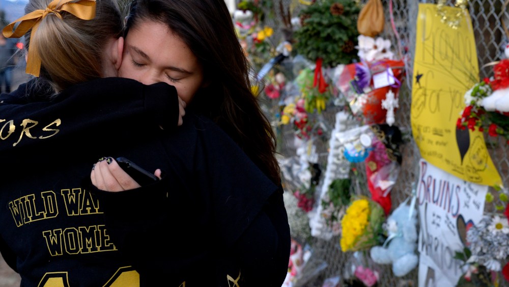 Seniors Lexi Barrent, right, and Melissa Tombaugh embrace outside Arapahoe High School in Centennial, CO Dec. 19, 2013