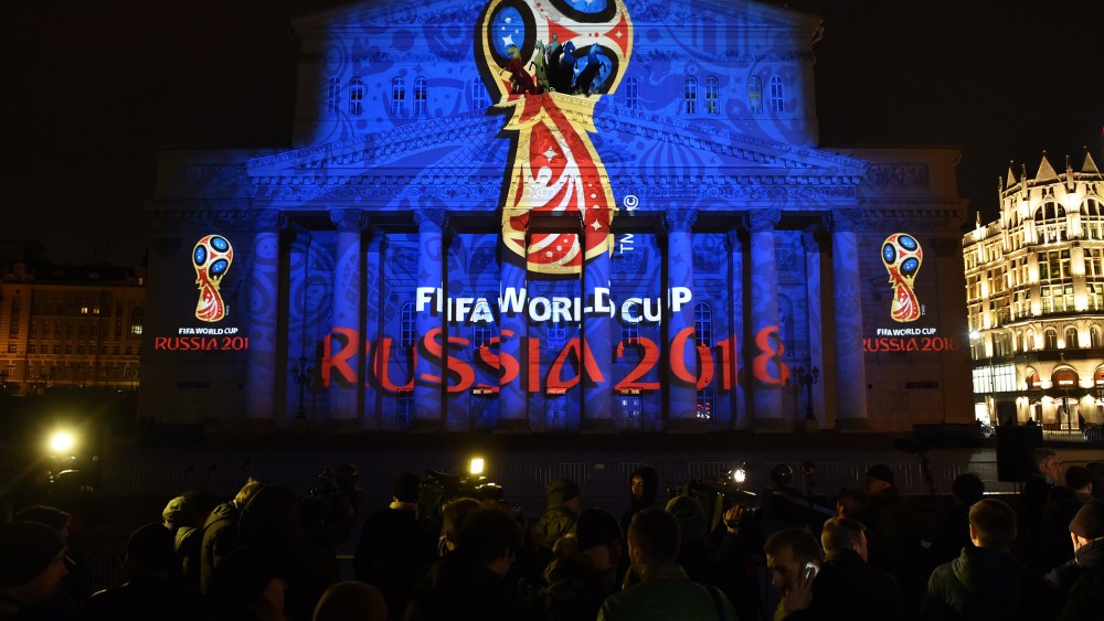 People watch as the facade of the historical Bolshoi Theatre is illuminated with the official emblem of the 2018 FIFA World Cup to be held in Russia in central Moscow on late Oct. 28, 2014. (Photo by Kirill Kudryavtsev/AFP/Getty)