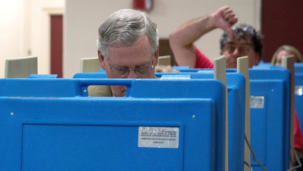 A voter gestures as Senate Minority Leader U.S. Sen. Mitch McConnell (R-KY) votes in the midterm elections at Bellarmine University on Nov. 4, 2014 in Louisville, Ky.