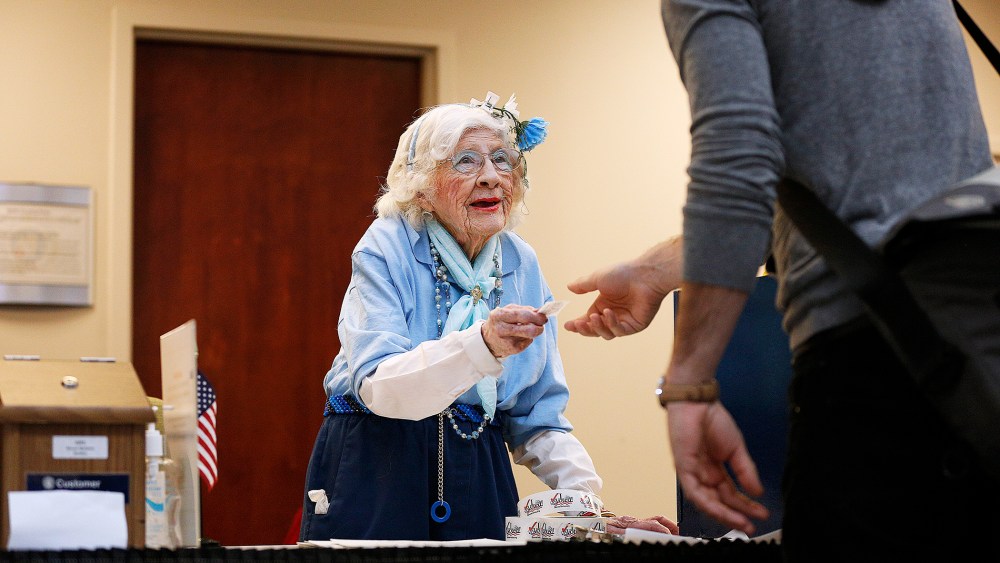 Elections judge Constance Rolon, 96, of Denver, Colorado hands out "I Voted!" stickers as voters cast their ballots at the Denver Elections Division Building on Nov. 4, 2014.