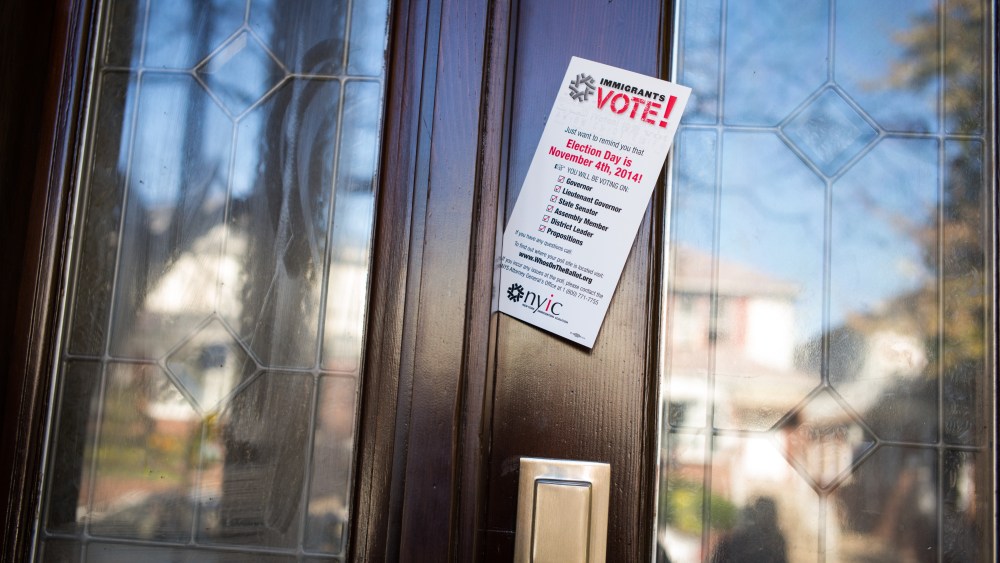 A pamphlet from the New York Immigrant Coalition is left in a door by volunteers from the Arab American Association of New York, AAANY, Nov. 4, 2014 in the Bay Ridge neighborhood of Brooklyn, N.Y. (Photo by Robert Nickelsberg/Getty)
