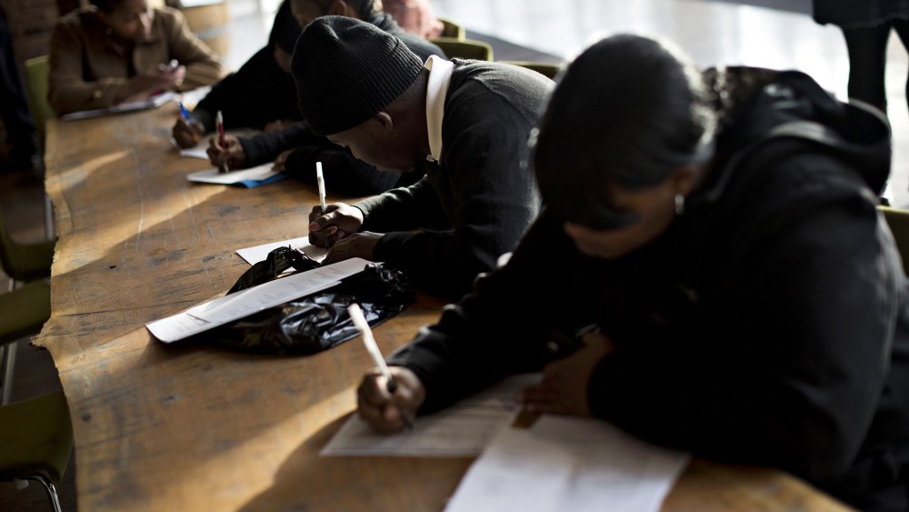 Job seekers fill out paperwork during a Virgin Hotels job fair in Chicago, Ill. on Nov. 5, 2014. (Photo by Daniel Acker/Bloomberg/Getty)