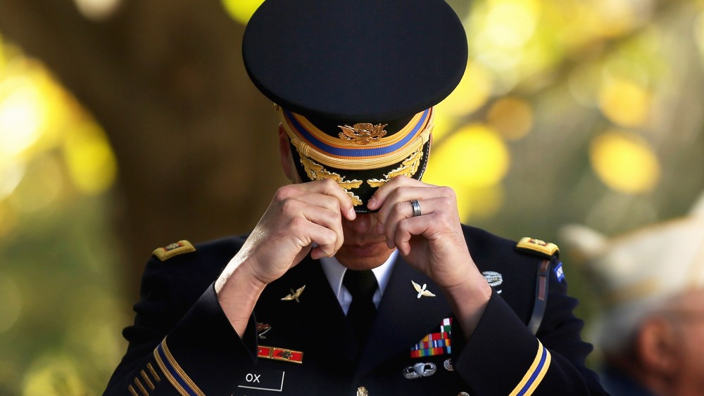 An officer from the 3rd U.S. Infantry Regiment adjusts his cover at The Tomb of the Unknown Soldier during Veterans Day observations at Arlington National Cemetery on Nov. 11, 2014 in Arlington, Va. (Photo by Chip Somodevilla/Getty)