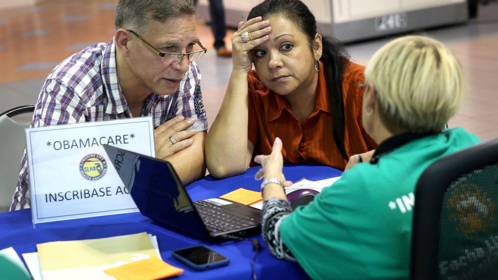 Angel Rivera (L) and his wife Wilma Rivera sit with, Amada cantera, an insurance agent with Sunshine Life and Health Advisors as they try to purchase health insurance under the Affordable Care Act at the kiosk setup at the Mall of Americas, Dec. 22, 2013