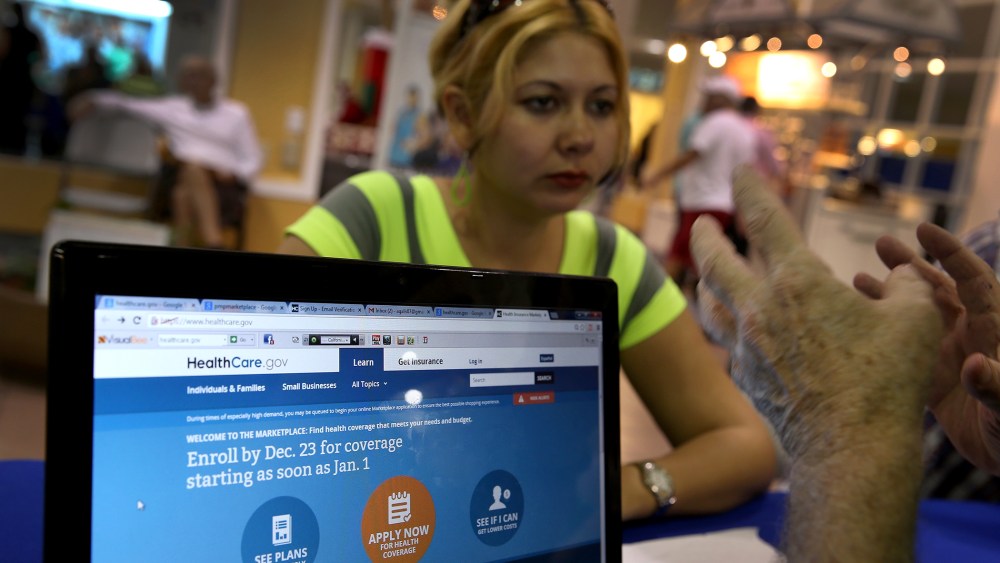 Rocelys Corrales of Miami sits with an insurance agent from Sunshine Life and Health Advisors as she inquires about purchasing health insurance, Dec. 22, 2013.